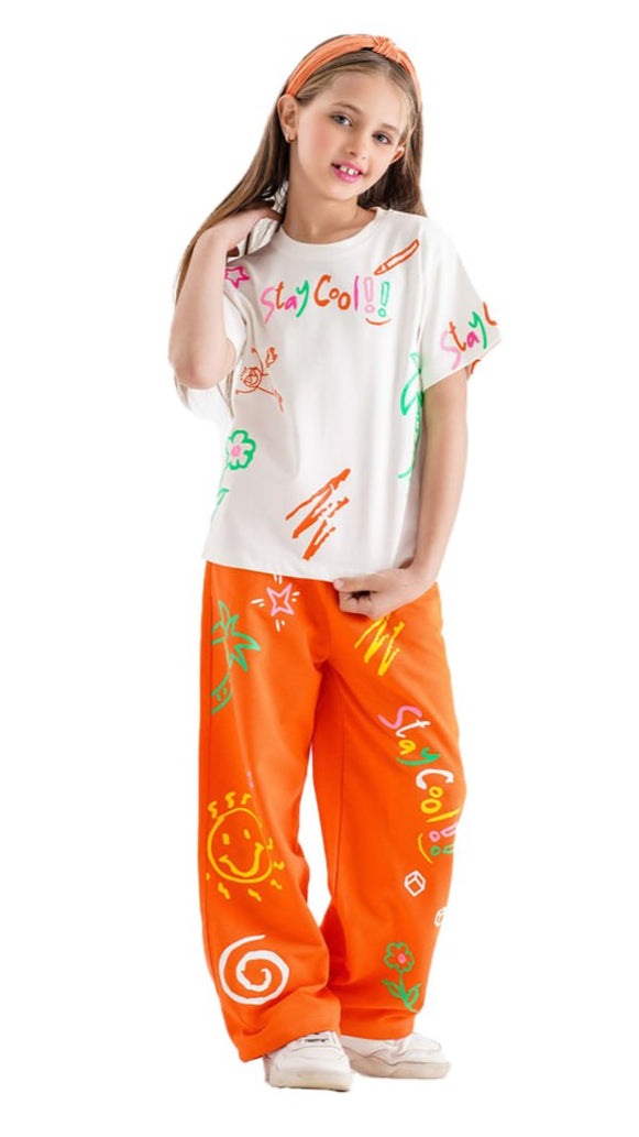 Child wearing a white t-shirt with colorful graphics and orange pants with patterns on a white background
