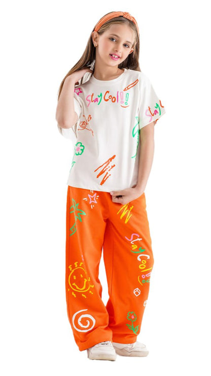 Child wearing a white t-shirt with colorful graphics and orange pants with patterns on a white background